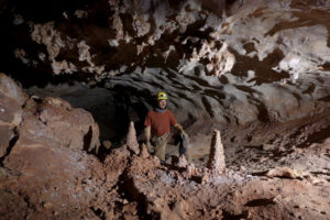 A caver near some smaller popcorn stalagmites